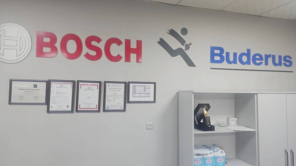 Servis ofisimizde Bosch ve Buderus logoları altında yetkili servis belgesi, mesleki yeterlilik belgeleri ve Premium Konsept ödülü